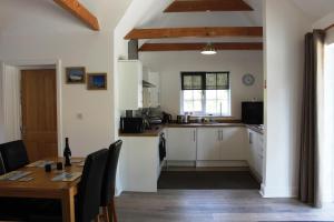 a kitchen with a table and a dining room at Greenacres in Kelsale