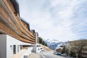 a building with a view of a mountain at Vacancéole - Les Ecrins d'Auris in Auris