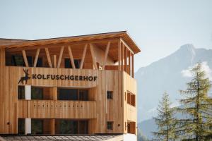 a building with a sign on the side of it at Kolfuschgerhof Mountain Resort in Colfosco