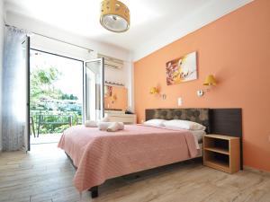 una camera da letto con un letto grande con pareti arancioni di Dolphin Apartments a Paleokastritsa