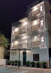 a white building with balconies and lights on it at Chippy Residency in Chennai