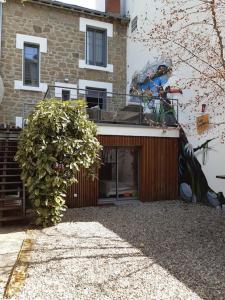 een gebouw met een grote struik ervoor bij Maison de ville chaleureuse in Brive-la-Gaillarde