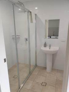 古尔本Carlton Suites的带淋浴和水槽的浴室