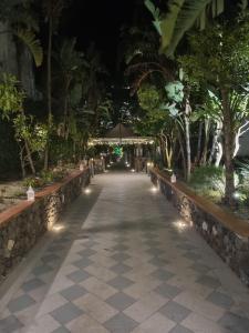 a walkway in a park at night with lights at L'Incanto Suites Ischia in Ischia
