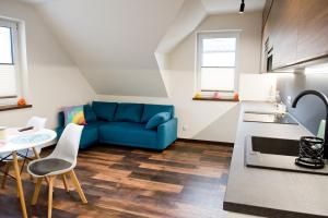 a living room with a blue couch and a table at Apartamenty Długa in Nowy Targ