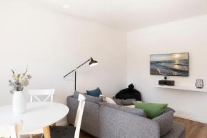 - un salon avec un canapé et une table dans l'établissement Haus Sonneninsel Wohnung 1, à Grömitz