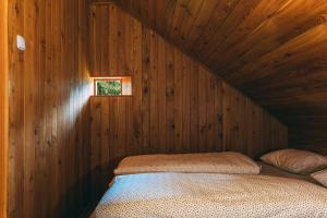 a bed in a wooden room with a window at Villa Šumik- Peaceful Hideaway in Ruše