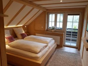 1 dormitorio con 1 cama en una habitación con ventanas en Ferienwohnung Waldrauschen in der Höhenpension Glashütte, en Bonndorf