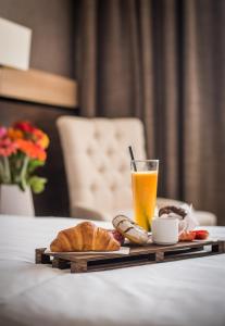 een tafel met een dienblad met eten en een glas sinaasappelsap bij Dunav Plaza Hotel in Ruse