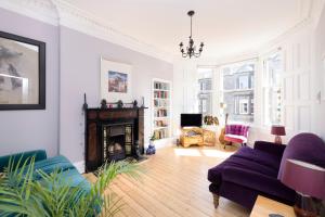 a living room with a couch and a fireplace at ALTIDO Gorgeous 1-bed flat with a shared garden in Edinburgh