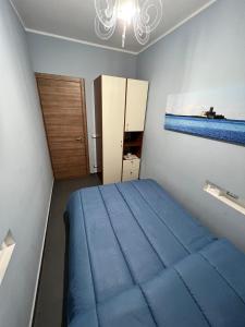een kleine slaapkamer met een blauw bed en een raam bij La Colombaia in Trapani