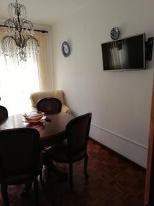 una sala da pranzo con tavolo, sedie e TV di Casas da Cacilda a Nazaré