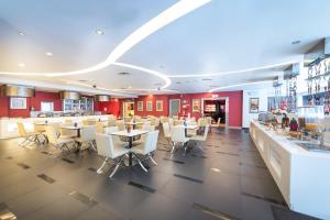 a restaurant with white chairs and tables and a bar at Hotel Sentral Pudu @ City Centre / Bukit Bintang in Kuala Lumpur