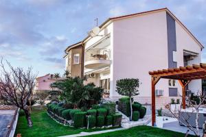 a house with a garden in front of it at Apartment and Rooms Ana in Podstrana