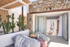 - un salon avec un canapé et un cactus dans l'établissement Adorno Beach Hotel and Suites, à Ornos