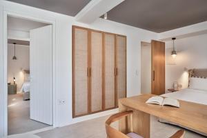a room with a wooden floor and a large window at Adorno Beach Hotel and Suites in Ornos