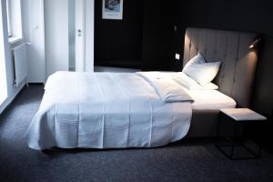 a bedroom with a bed with a white comforter at Magni Boutique Hotel in Braunschweig