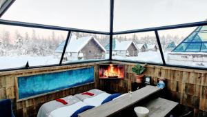 a room with two beds and a fireplace at Aurora Pyramid Glass Igloos in Köngäs