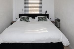 a large white bed in a room with a window at #MacLeod2 in Ostend