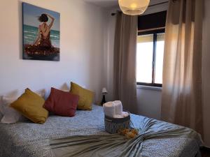 ein Schlafzimmer mit einem Bett und ein Gemälde einer Frau in der Unterkunft Sunrise Apartment 3BR (Free Wi-Fi) in Peniche