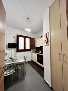 een kleine keuken met een tafel en een koelkast bij La Colombaia in Trapani