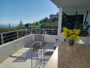 een balkon met 2 stoelen en een vaas met gele bloemen bij Villa Malibu in Mandelieu-la-Napoule