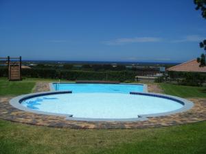 una gran piscina en un patio de césped en L4 Goose Valley Golf Estate, en Plettenberg Bay