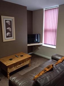 a living room with a couch and a coffee table at clazzers apartment 2 in Bridlington