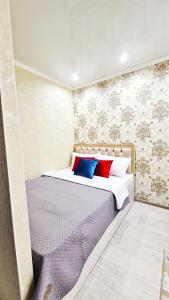 Un dormitorio con una cama con almohadas de colores. en Абсолютно новая квартира класса ЛЮКС en Taraz