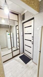 Cette chambre comprend une porte et un miroir. dans l'établissement Абсолютно новая квартира класса ЛЮКС, à Taraz