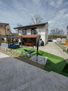 a house with a patio with a table and chairs at Vila Maria băile felix in Baile Felix