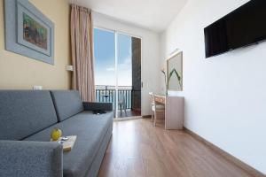 salon z kanapą i dużym oknem w obiekcie Relaxia Beverly Park w mieście Playa del Ingles