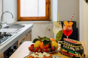 a table with a bowl of fruit and a drink at Piazza delle Vettovaglie Historic Center Eco Flat in Pisa