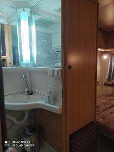 La salle de bains est pourvue d'un lavabo et d'un miroir. dans l'établissement camping hydraswave bungalow caravan, à Thermisía