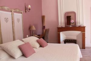 a bedroom with a bed with pink walls and a mirror at Hôtel et Restaurant Le Manoir - Echangeur A7-A9 - 24h-24h in Mornas