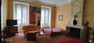 a living room with a fireplace and a tv at Le Manoir in Mornas