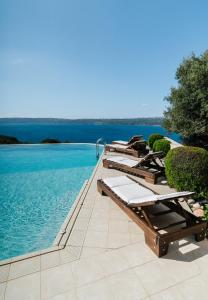 szereg leżaków na skraju basenu w obiekcie Your-Villa, Villas in Crete w Chanii