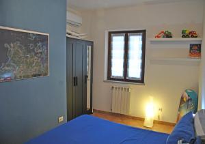 een slaapkamer met een blauw bed en een raam bij Gallura 2 in La Maddalena