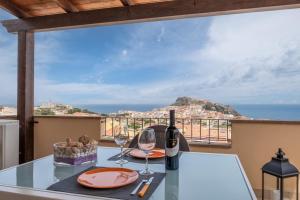 a table with wine glasses and a view of the ocean at CASTELSARDO- Elegante Appartamento vista Mare in Castelsardo
