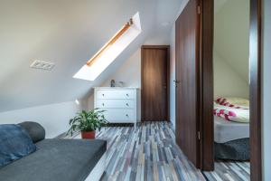 Buzavirág Apartman في كيزتيلي: غرفة نوم علوية مع سرير وعلبة درج