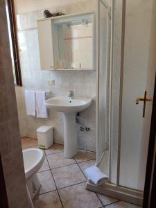 een badkamer met een wastafel, een douche en een toilet bij Affittacamere La Rondinella in Montemerano