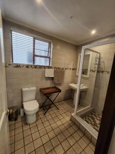 uma casa de banho com um WC e um lavatório em Melville Turret Guesthouse em Joanesburgo
