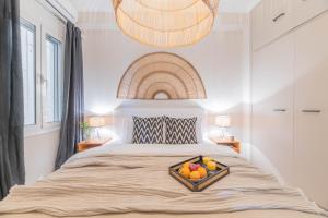 Un dormitorio con una cama con una bandeja de fruta. en Minimal Retreat w/ Watercoloured Sunset View en Pireo