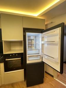 een lege keuken met een lege koelkast en een open oven bij Istanbul Suites Residance Super Lux BKY in Istanbul