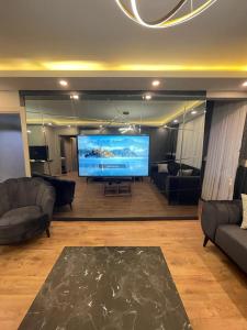 een grote woonkamer met een groot televisiescherm bij Istanbul Suites Residance Super Lux BKY in Istanbul