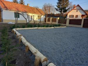 un patio trasero con una entrada de grava y una casa en GALAMBLAK Vendégház, en Abaújszántó