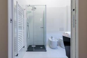 a bathroom with a glass shower with a toilet and a sink at Marie Claire Apartments & Spa in Vasto