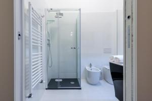 bagno con doccia in vetro, servizi igienici e lavandino di Marie Claire Apartments & Spa a Vasto