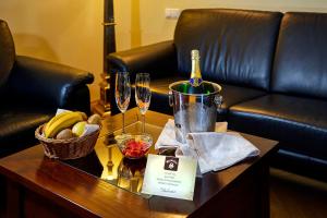 einen Tisch mit einer Flasche Wein und Gläsern darauf in der Unterkunft Salvator Hotel in Karlsbad
