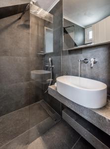 La salle de bains est pourvue d'un lavabo et d'une douche en verre. dans l'établissement Sofaki Milos, à Trypiti